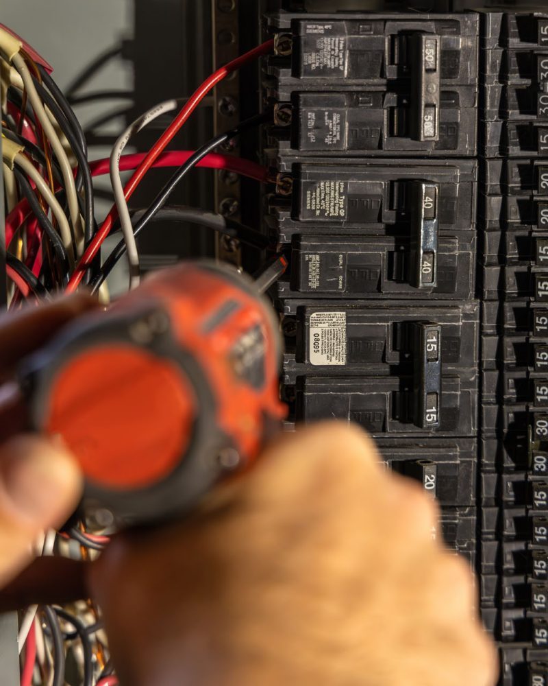 Electrician working on a residential electrical panel in Matthews, NC
